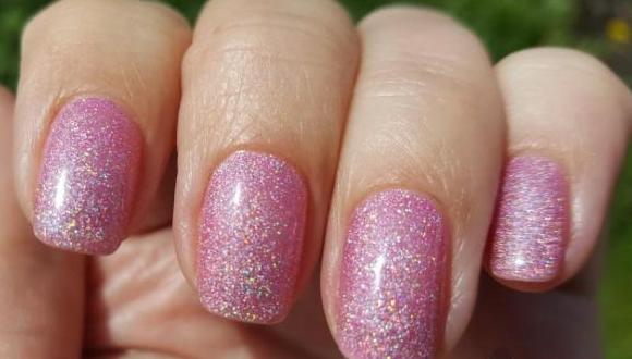 Polonês de gel de manicure delicadamente rosa com brilhos, fricção, strass, prata, preto, branco, azul, dourado. Uma foto