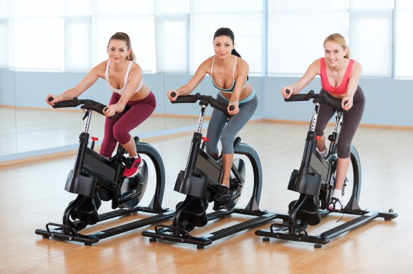 Fer exercici amb una bicicleta d’exercici per perdre pes. Sistema de crema de greixos per a dones i homes principiants