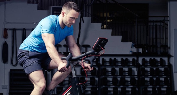 Faça exercícios em uma bicicleta ergométrica para perder peso. Sistema de queima de gordura para mulheres e homens iniciantes