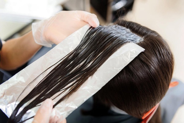 Mitjans per allisar i allisar el cabell a llarg termini amb una planxa, queratina